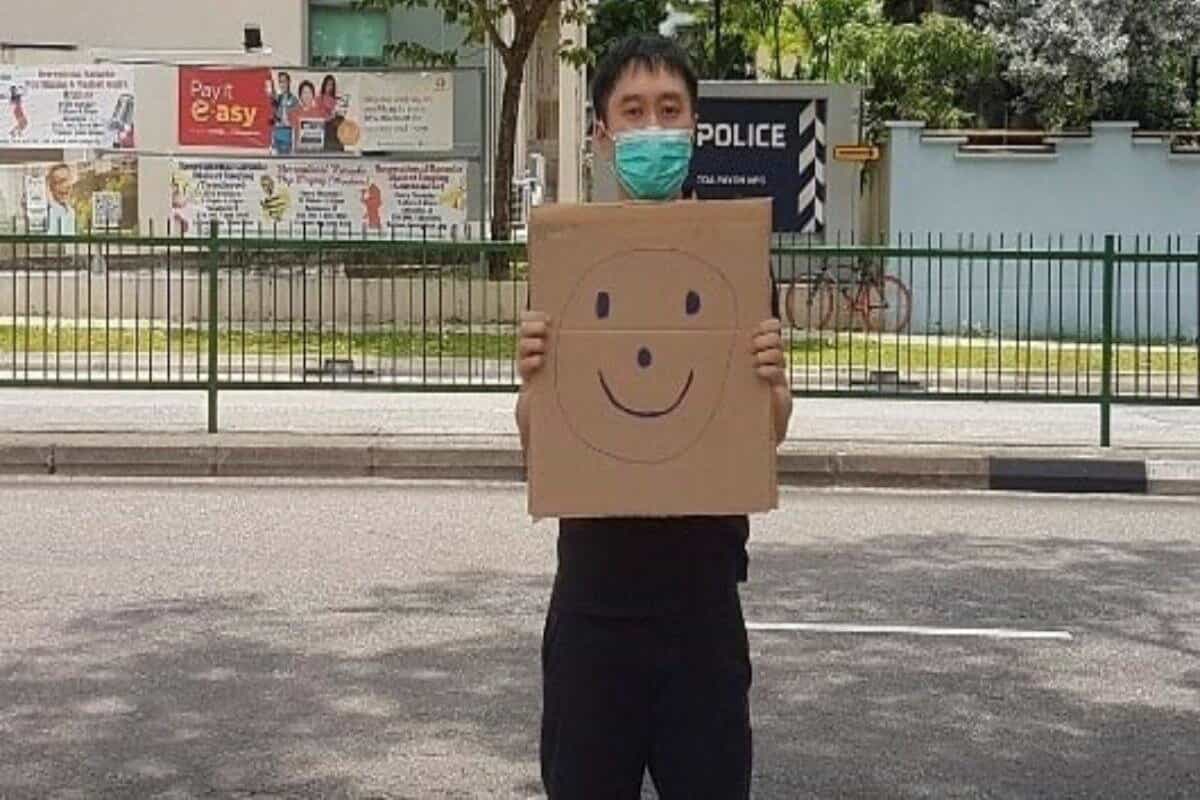 Singapore activist faces fine over one-man smiley face sign protest